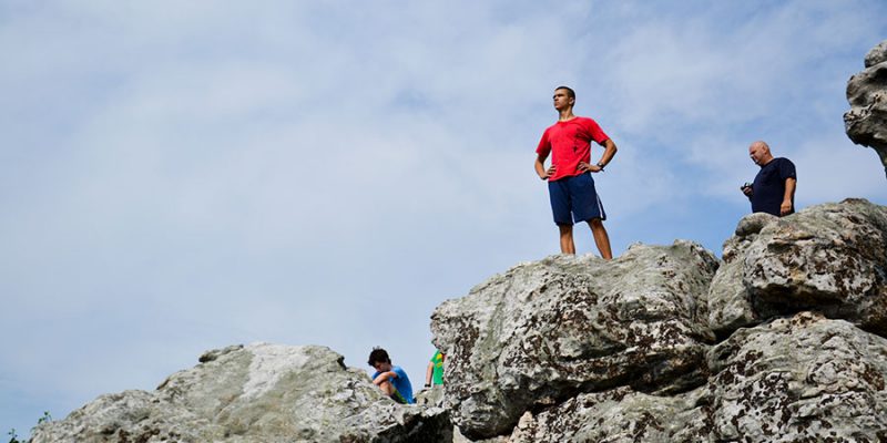 Young man looking into the distance from a rocky cliff