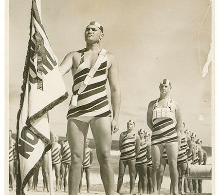 1935 sepia photo of North Bondi beach males in striped, full-body bathing costumes complete with bathing caps