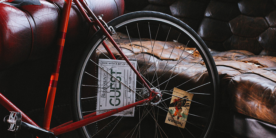 unsplash photo of a bicycle wheel and an old, worn, wrinkled sofa